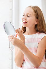 Image showing teenage girl with lip gloss and mirror