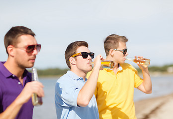 Image showing friends on the beach with bottles of drink