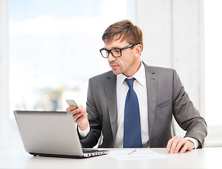 Image showing businessman working with laptop and smartphone