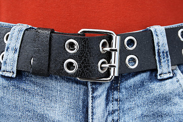 Image showing Black leather belt and blue jeans