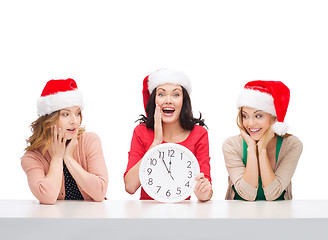 Image showing women in santa helper hats with clock showing 12