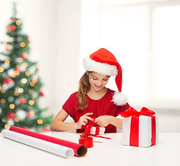 Image showing smiling girl in santa helper hat with gift box