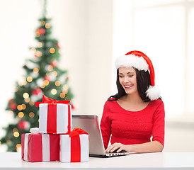 Image showing woman with gift boxes and laptop computer