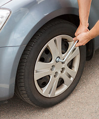 Image showing man changing tire