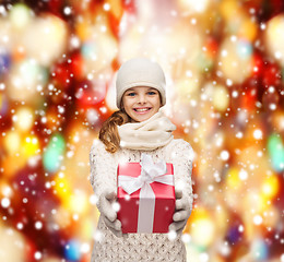 Image showing girl in hat, muffler and gloves with gift box