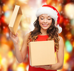 Image showing smiling woman in santa helper hat with gift box