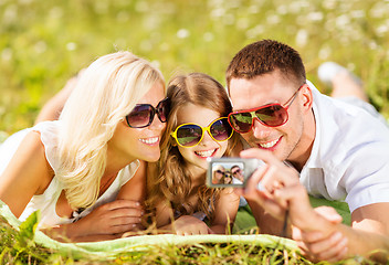 Image showing happy family with camera taking picture