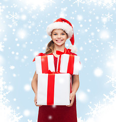 Image showing girl in santa helper hat with many gift boxes