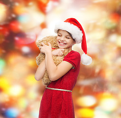 Image showing smiling girl in santa helper hat with teddy bear