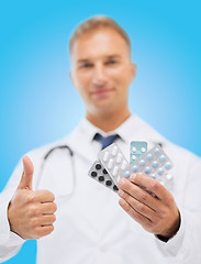 Image showing male doctor with packs of pills