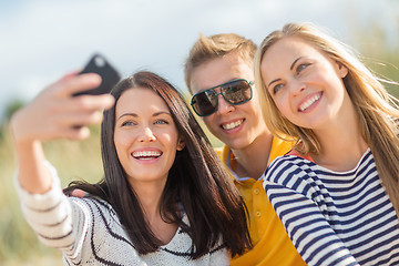 Image showing group of friends taking picture with smartphone