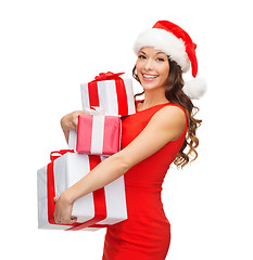 Image showing smiling woman in red dress with many gift boxes