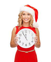 Image showing woman in santa helper hat with clock showing 12