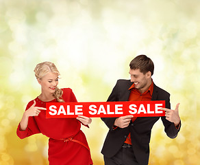 Image showing smiling woman and man with red sale sign