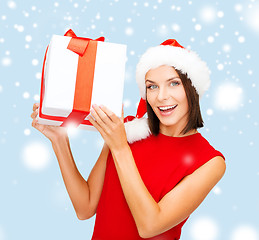 Image showing smiling woman in santa helper hat with gift box