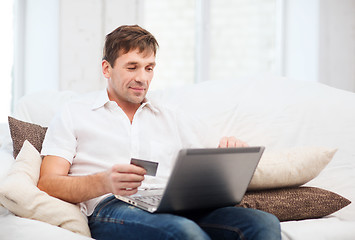 Image showing man with laptop and credit card at home