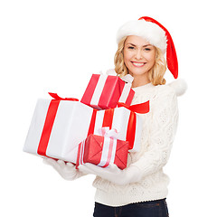 Image showing woman in santa helper hat with many gift boxes