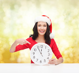 Image showing woman in santa helper hat with clock showing 12