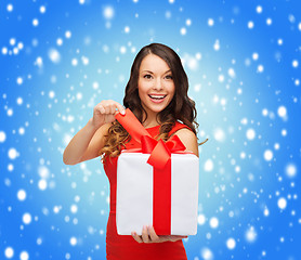 Image showing smiling woman in red dress with gift box