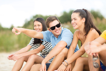 Image showing group of friends pointing somewhere on the beach