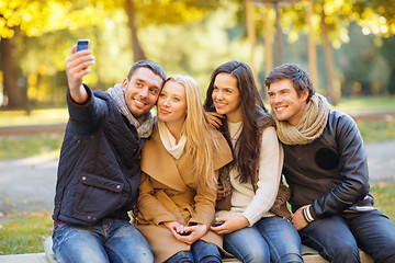 Image showing group of friends with photo camera in autumn park