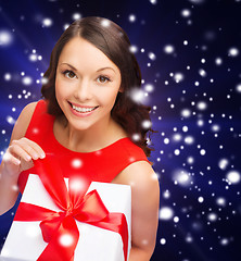 Image showing smiling woman in red dress with gift box