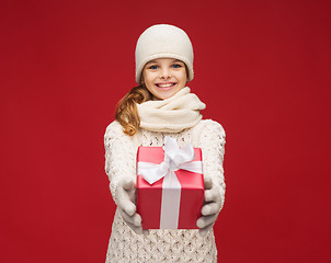 Image showing girl in hat, muffler and gloves with gift box