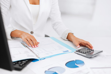 Image showing woman hand with calculator and papers