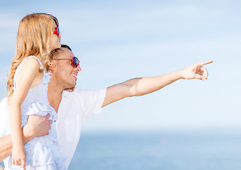 Image showing happy father and child in sunglasses over blue sky