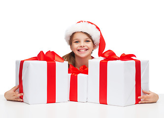 Image showing girl in santa helper hat with many gift boxes