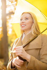 Image showing woman with yellow umbrella in the autumn park