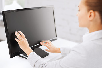 Image showing smiling businesswoman with touchscreen in office