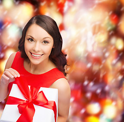 Image showing smiling woman in red dress with gift box