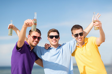 Image showing friends on the beach with bottles of drink