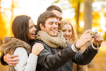 Image showing group of friends with photo camera in autumn park