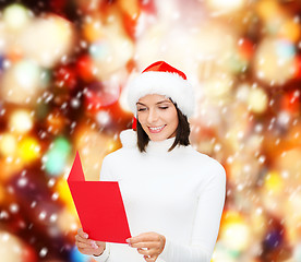Image showing woman in santa helper hat with blank red postcard