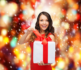 Image showing smiling woman in red dress with gift box