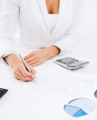 Image showing businesswoman working with calculator in office