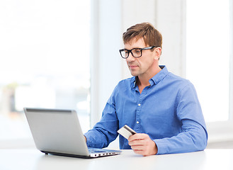 Image showing man with laptop and credit card at home