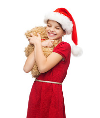 Image showing smiling girl in santa helper hat with teddy bear