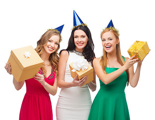 Image showing three smiling women in blue hats with gift boxes