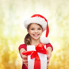 Image showing smiling girl in santa helper hat with gift box