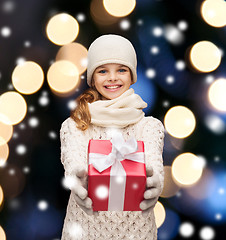 Image showing girl in hat, muffler and gloves with gift box