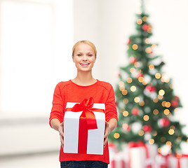 Image showing smiling woman in red sweater with gift box