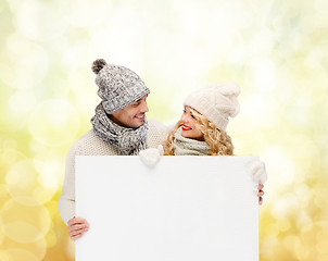 Image showing couple in winter clothes with blank white board