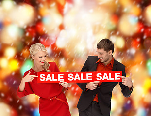 Image showing smiling woman and man with red sale sign