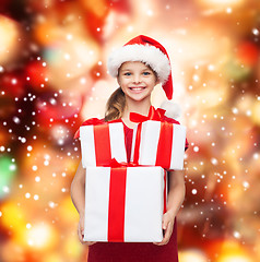 Image showing girl in santa helper hat with many gift boxes