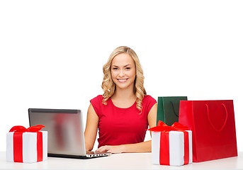 Image showing woman with gift boxes, bags and laptop computer