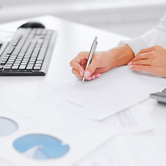 Image showing businesswoman working with calculator in office