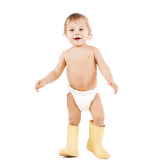 Image showing cute little boy walking in big rubber boots